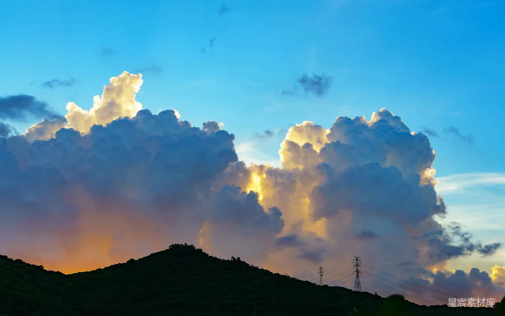 高清摄影 夕阳下戏剧性的云层照亮了黑暗的山丘。