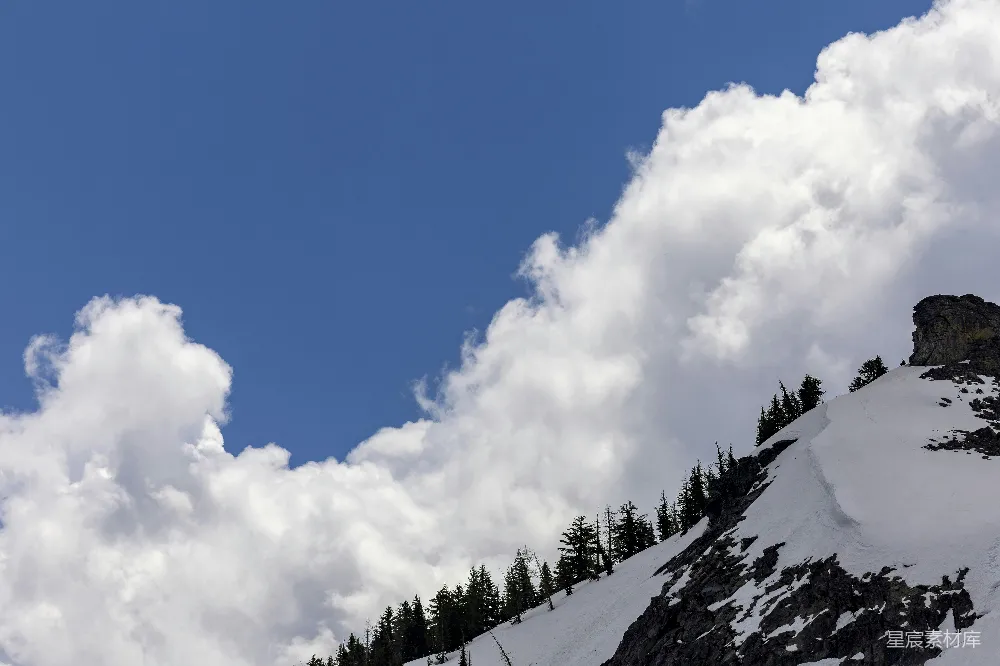 高清摄影 覆盖着白雪的山峦在半阴天的背景下