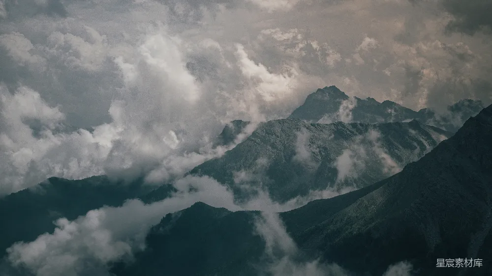 高清摄影 山峰穿透弥漫的戏剧性天空。
