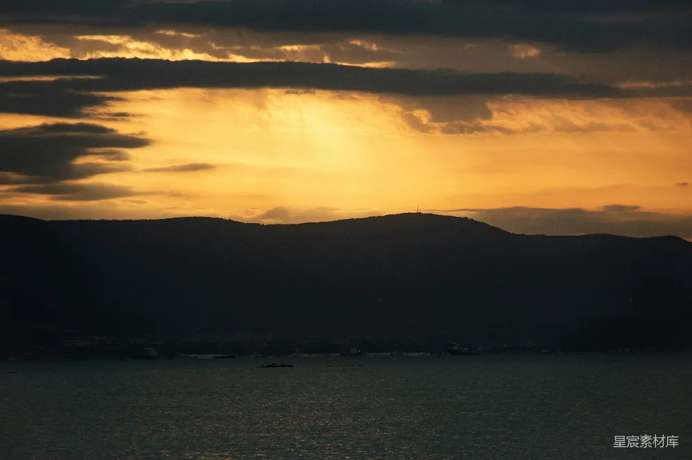 高清摄影 夕阳映照着黑暗的山峦和宁静的水面。