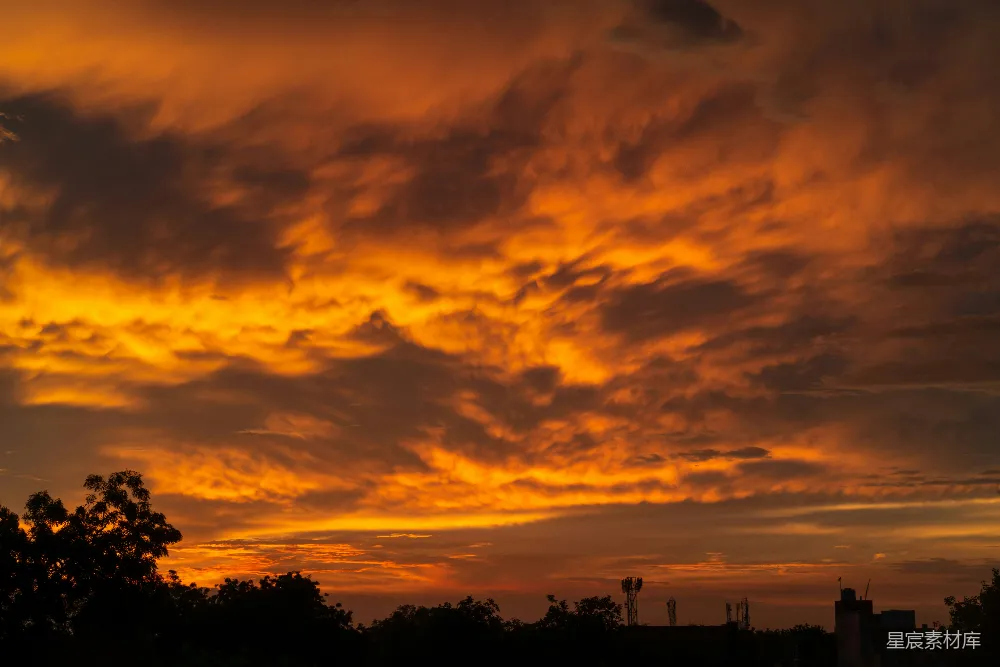 高清摄影 夕阳西下，天空中弥漫着炽烈的橙色云彩。