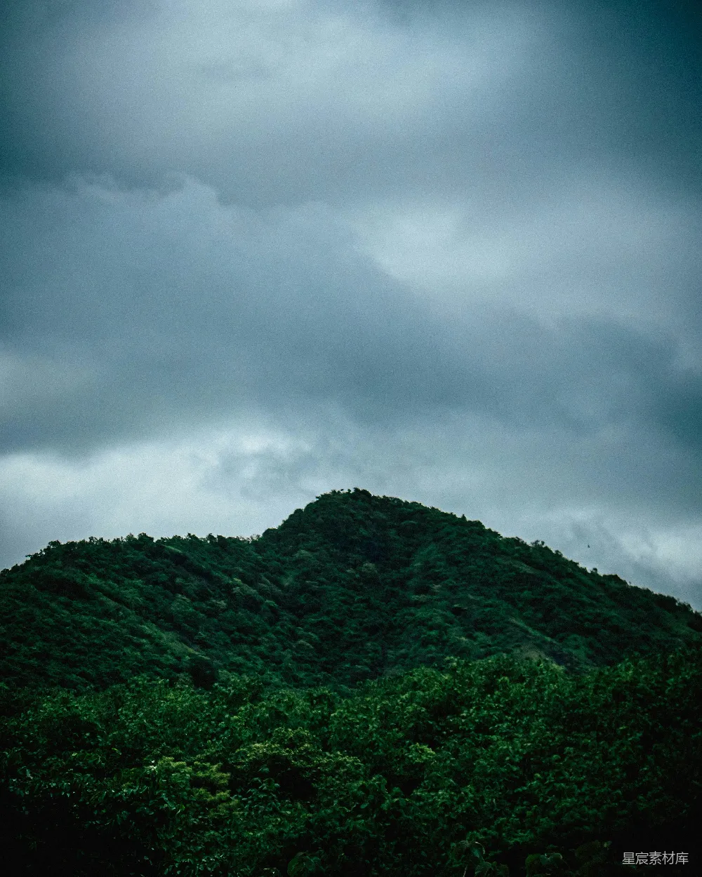 高清摄影 灰色云层下的绿山
