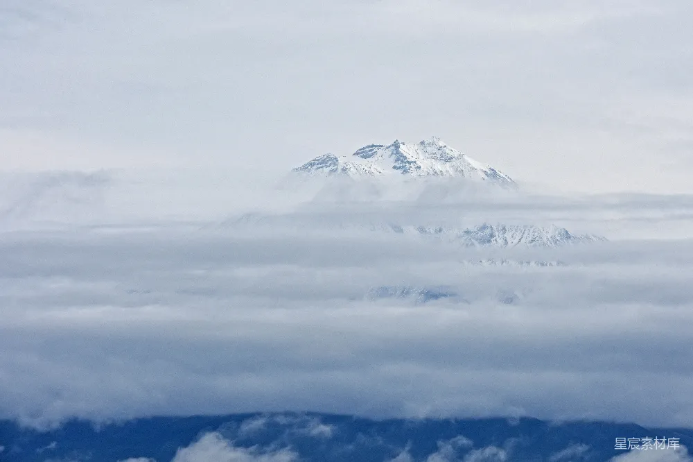 高清摄影 白天雪冠山被云环绕