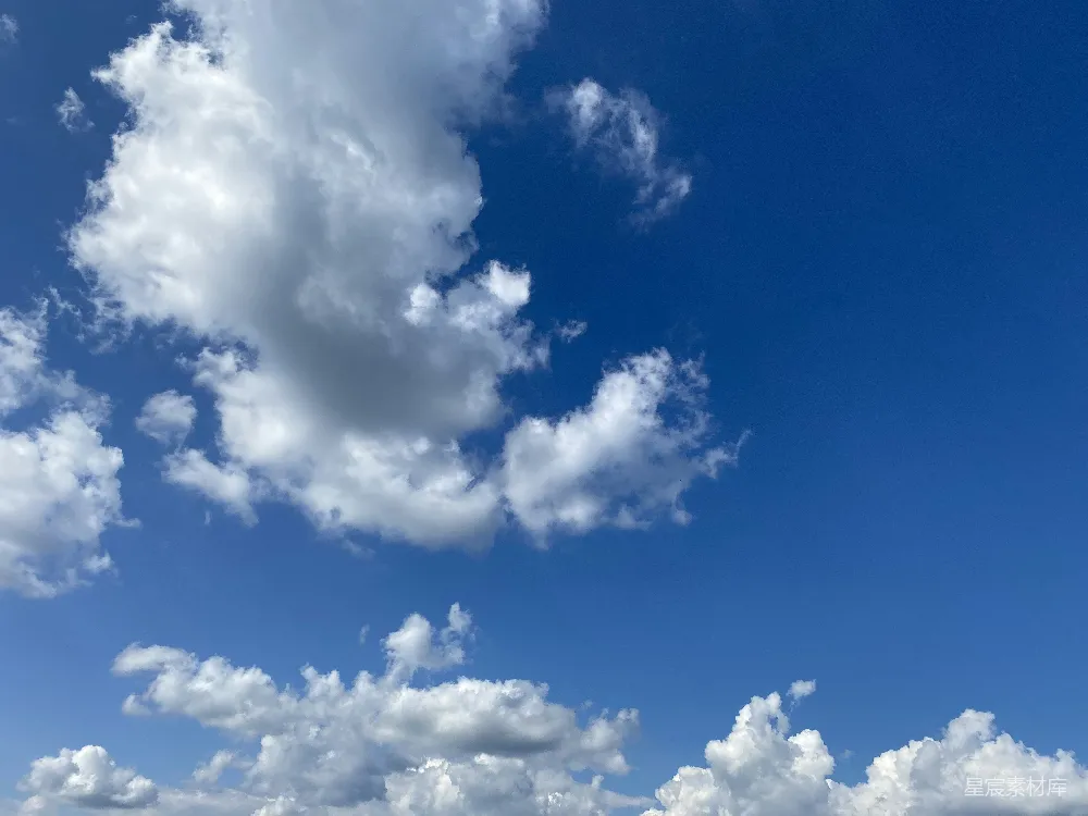 高清摄影 一群人在云彩蓝色天空下的海滩上站立。
