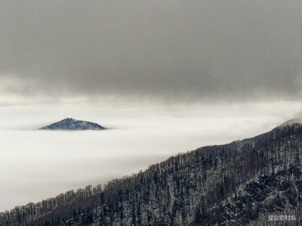 高清摄影  低矮云雾覆盖的一座山峰的景象