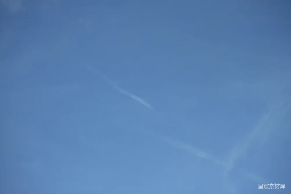 高清摄影 天空中飞行的飞机伴有长长的尾迹云。