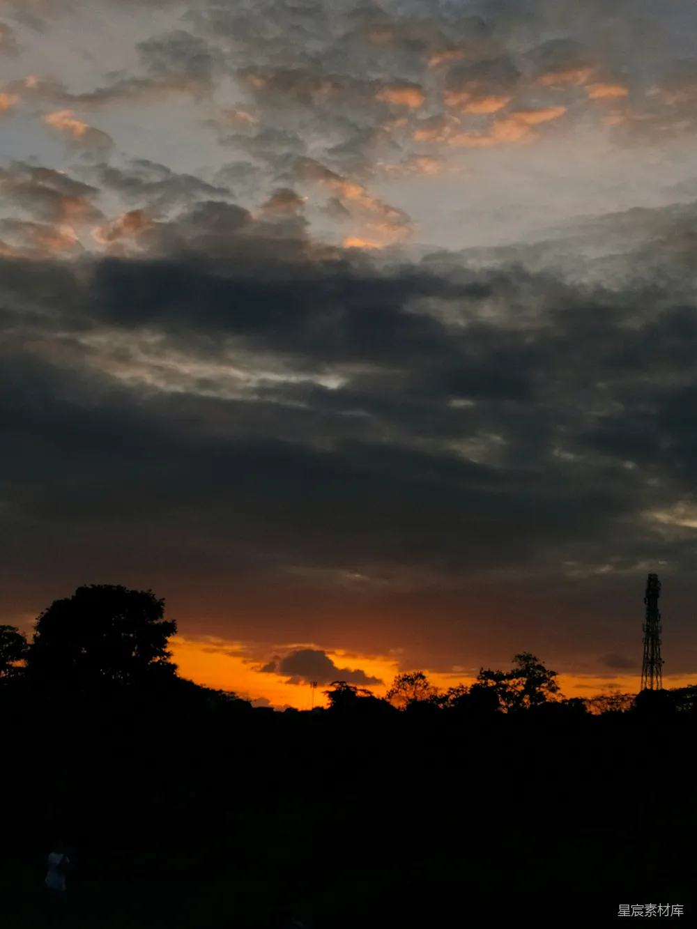 高清摄影 夕阳西下，远处有一座塔。