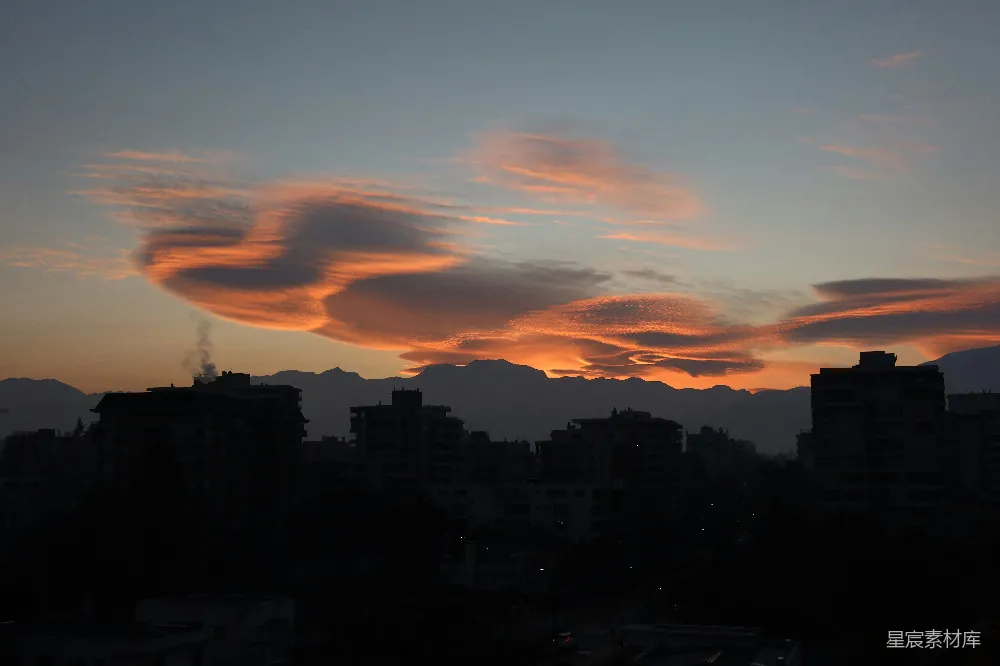 高清摄影 夕阳下，城市 skyline上弥漫着戏剧性的云霞光辉。