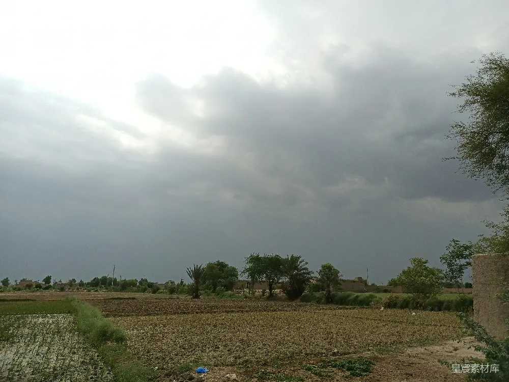 高清摄影 一片广阔的田野，天空中云朵密布。