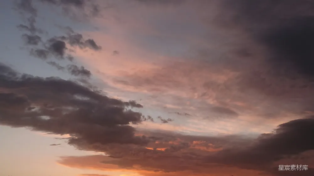 高清摄影 夕阳下的多彩云朵，呈现出粉色和橙色的色彩。