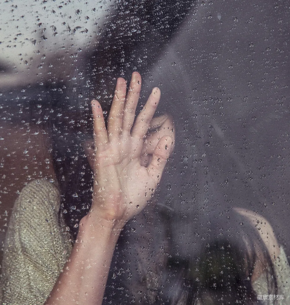 高清摄影 女人触摸着雨淋的玻璃。
