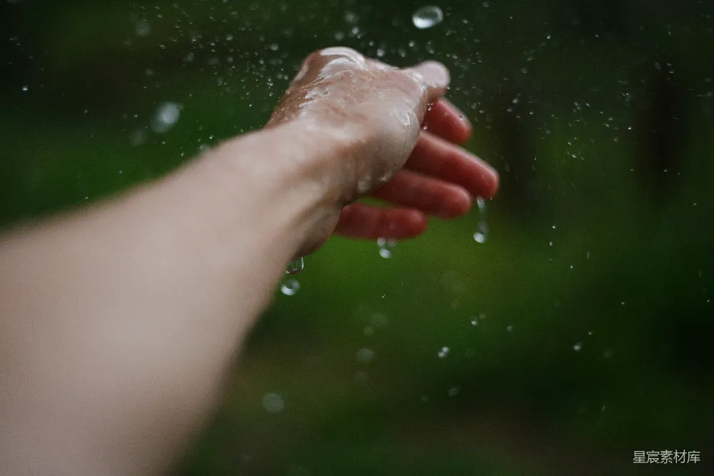 高清摄影 一个人伸手去拿雨中的东西。