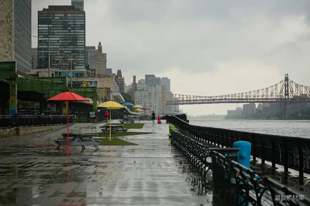 高清摄影 雨天城市街道，有长椅和伞。