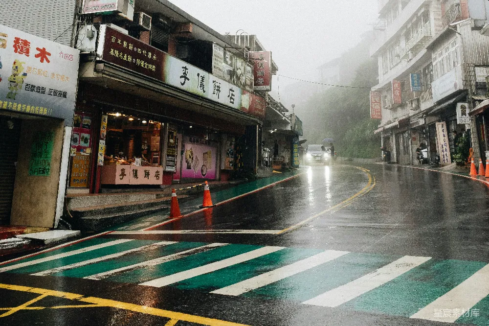 高清摄影 路面上白天行驶的车辆附近有建筑物