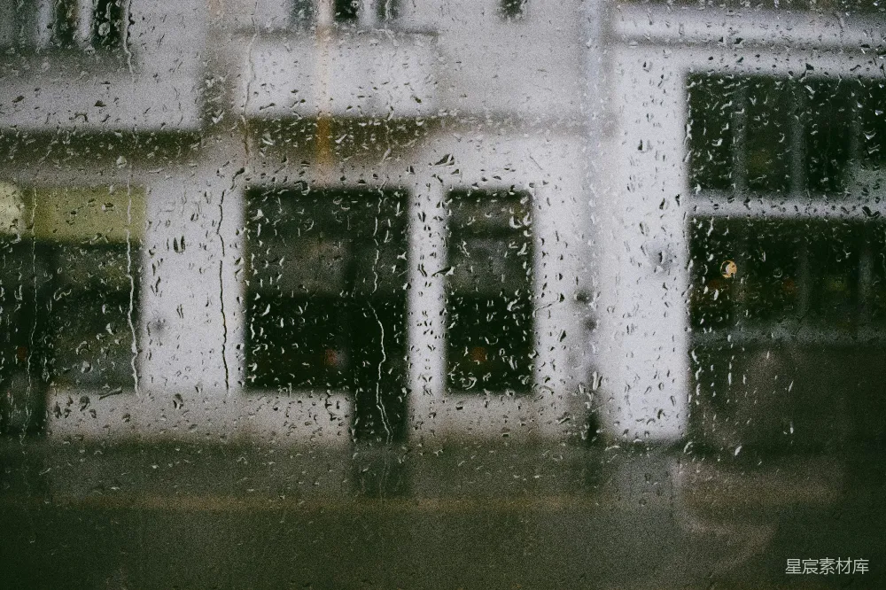 高清摄影 雨中的一扇窗户，背景是建筑物。