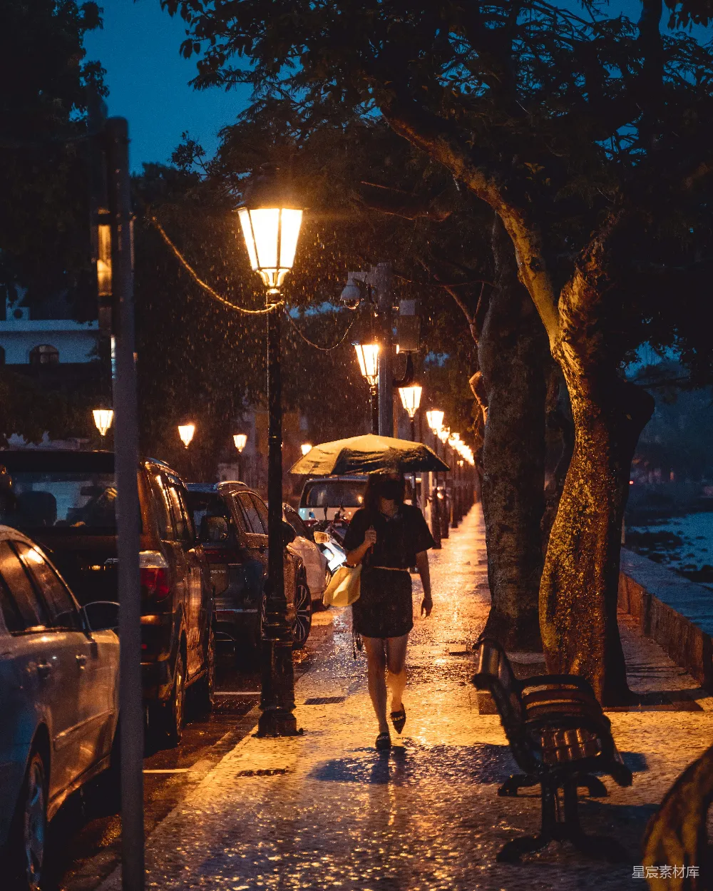 高清摄影 一个女人走在人行道上拿着雨伞