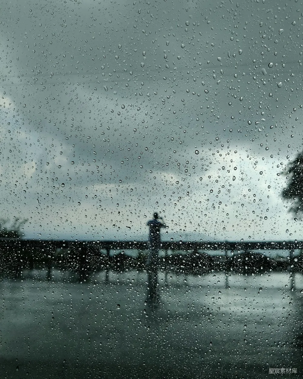 高清摄影 桥上站着一个人，在雨中。