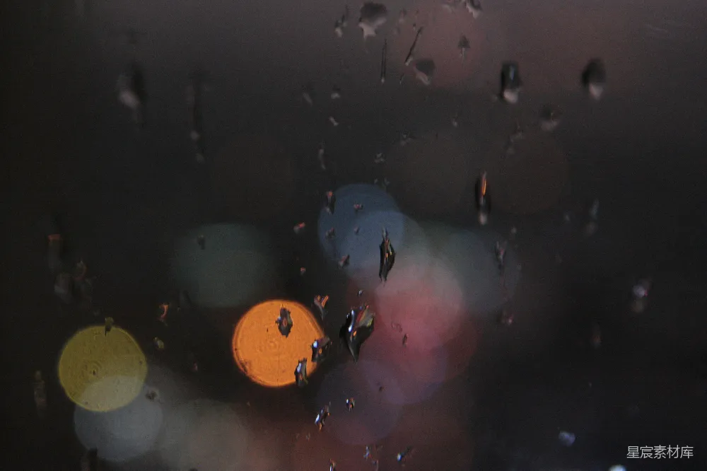 高清摄影 窗玻璃上滴落的雨珠与模糊的城市灯光。