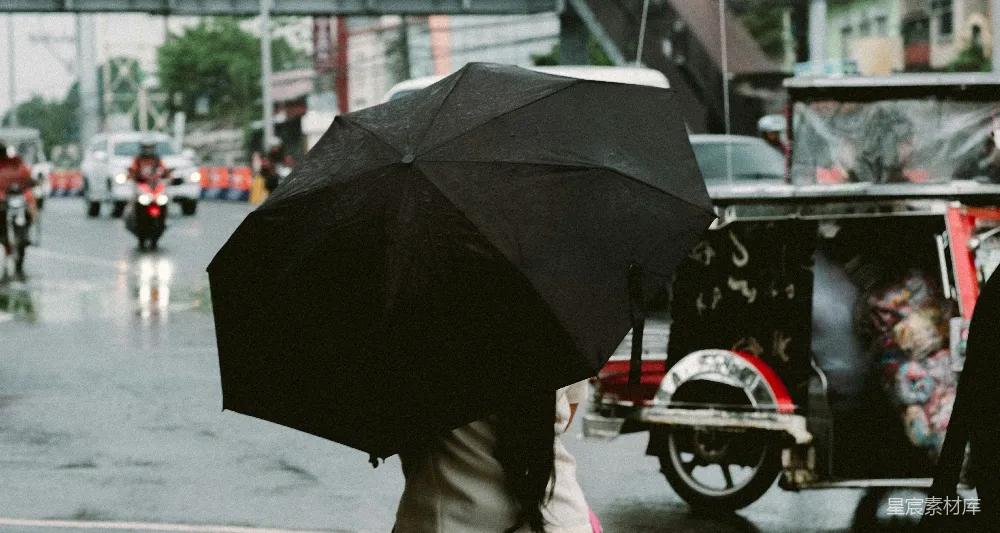 高清摄影 一个男子走在街上拿着雨伞。