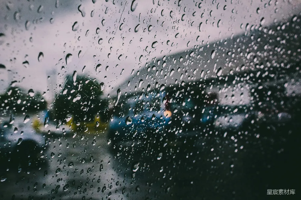 高清摄影 背景中有车辆停放，窗户上覆盖着雨水。