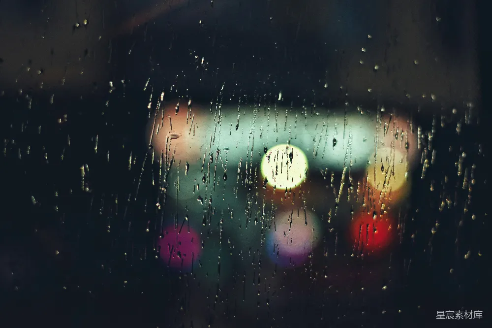高清摄影 透过蒙上雨水的窗户看去，模糊不清的一盏街灯的图像。