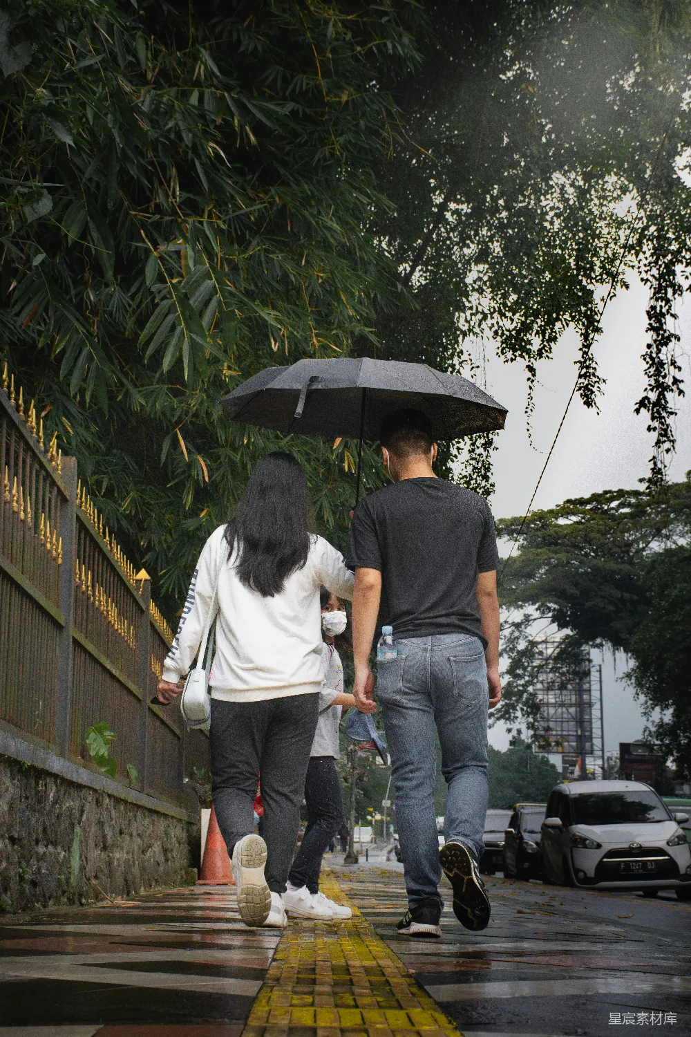 高清摄影 一个男人和一个女人打着伞走在路上。