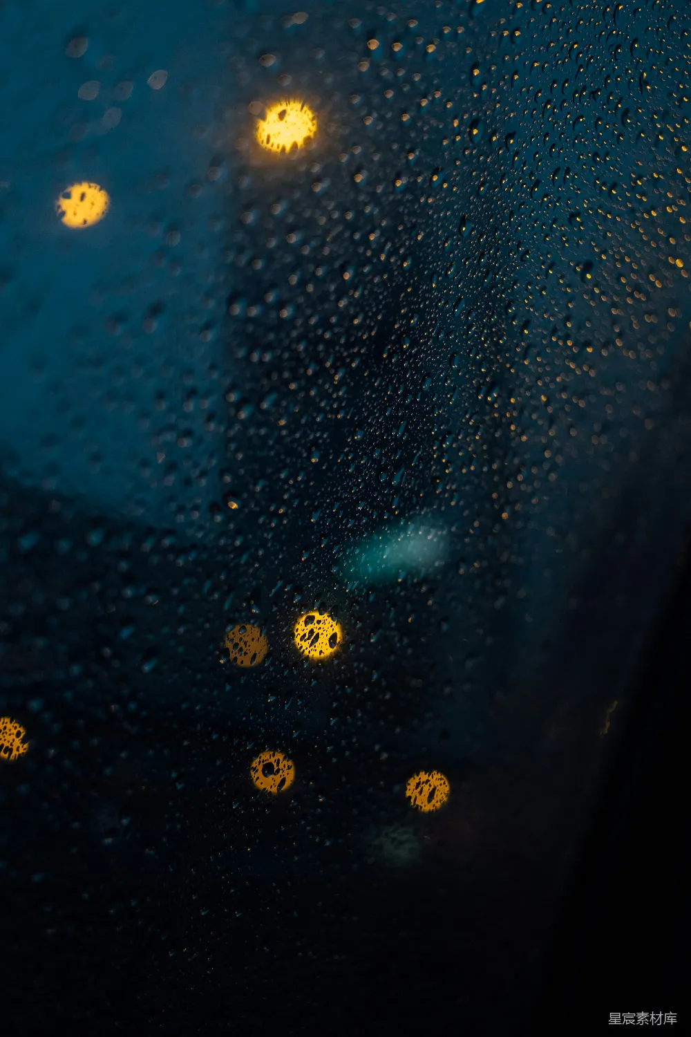 高清摄影 雨滴落在有黄色灯光的玻璃窗上