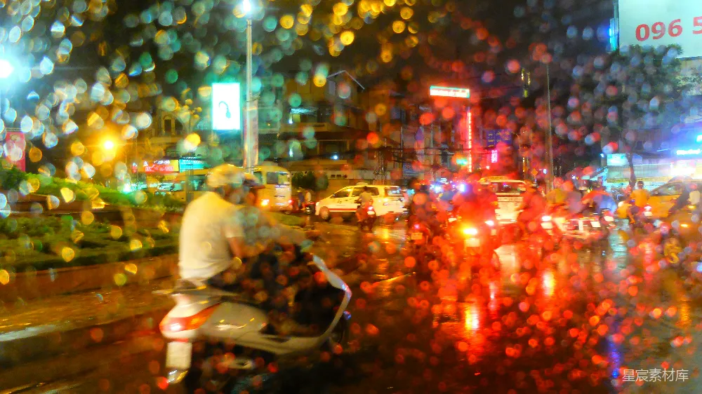 高清摄影 一个男人在一条被雨水浸湿的街道上骑着摩托车。
