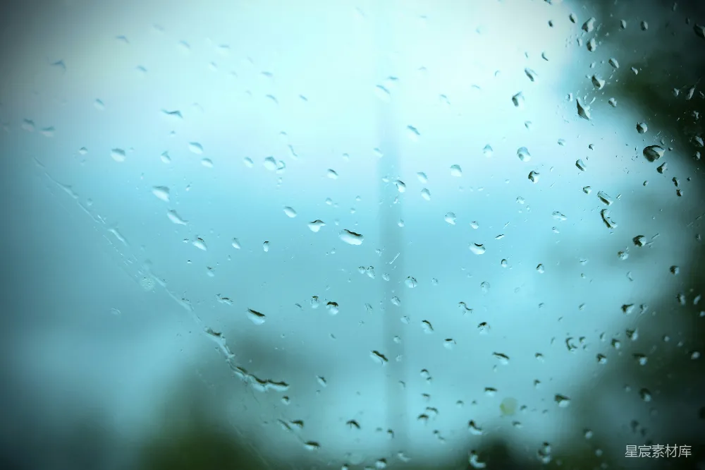 高清摄影 玻璃窗上的雨滴创造了一个模糊的蓝色景象。