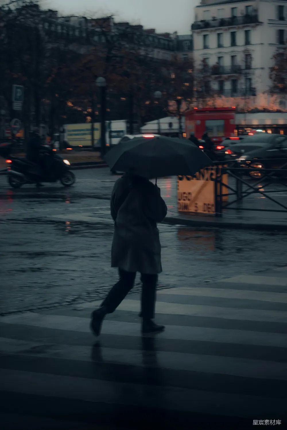 高清摄影 一位妇女正在街上行走，手中撑着雨伞。