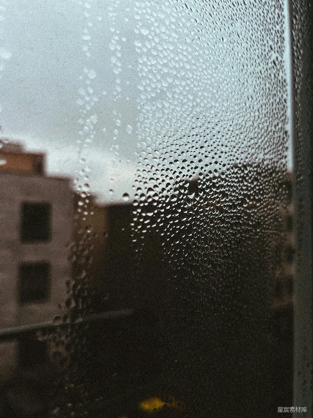 高清摄影 窗户上挂着雨滴，背景是一座建筑。