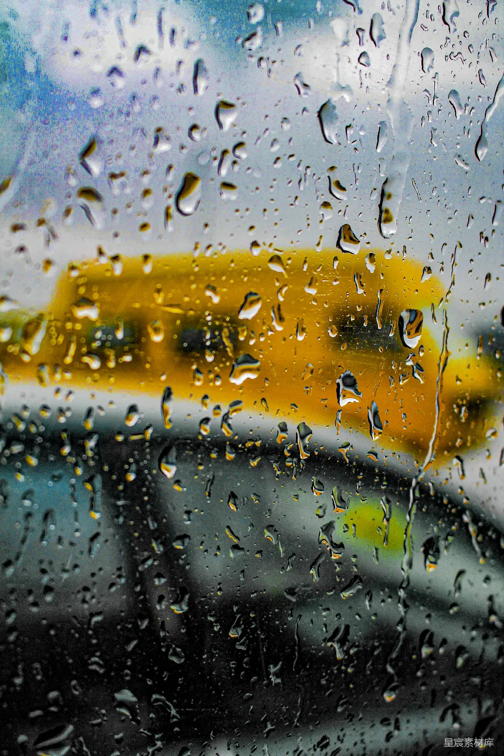 高清摄影 雨淋湿的窗户旁边有一辆校车。