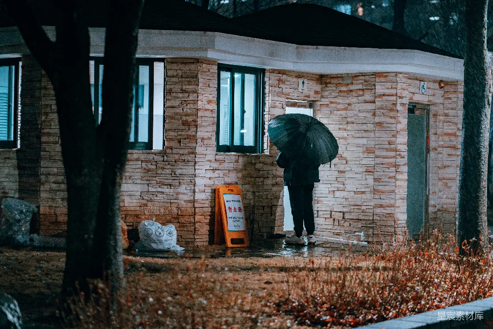 高清摄影 黑色夹克的人白天站在棕色砖砌建筑物附近。