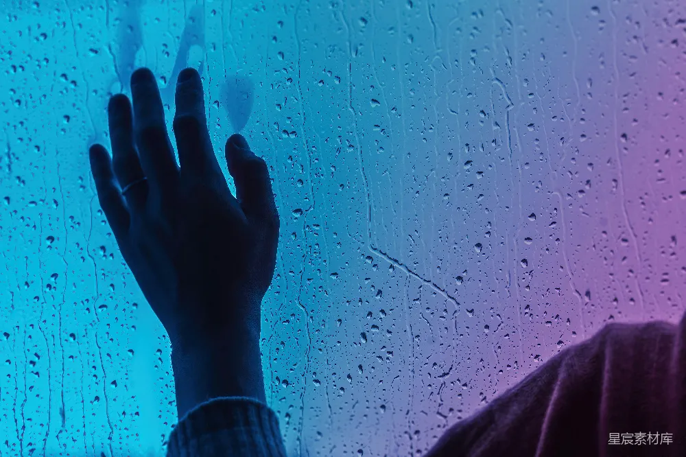 高清摄影 站在窗前的人被雨水覆盖着。