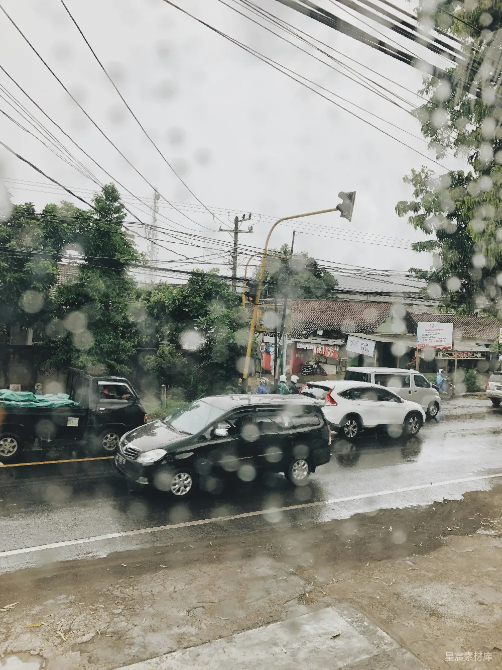 高清摄影 一条被雨水打湿的街道，车辆停在路边。