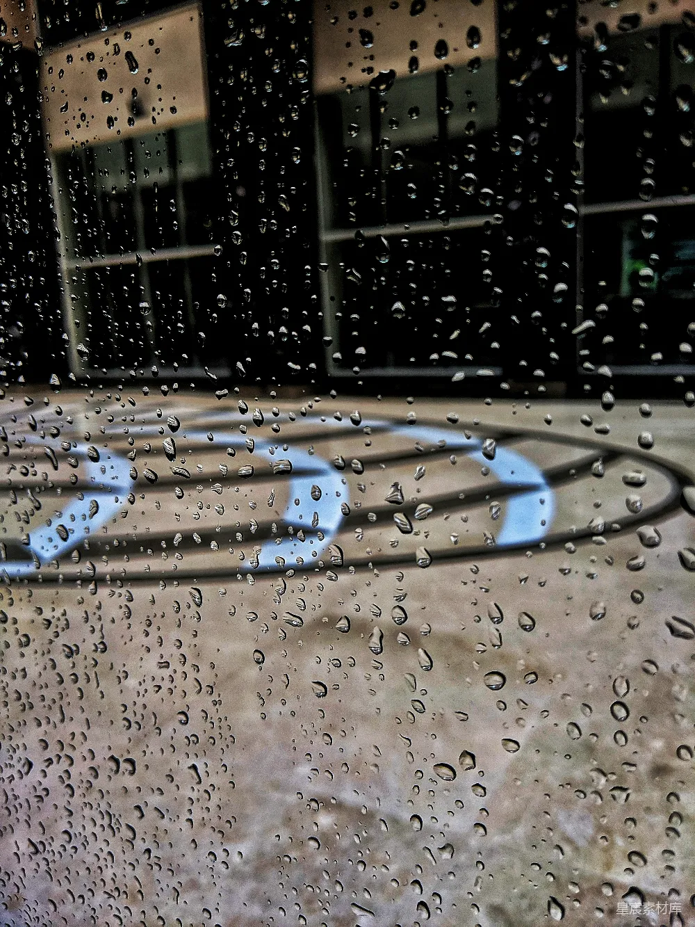 高清摄影 窗户上挂着雨滴，背景有一栋建筑。