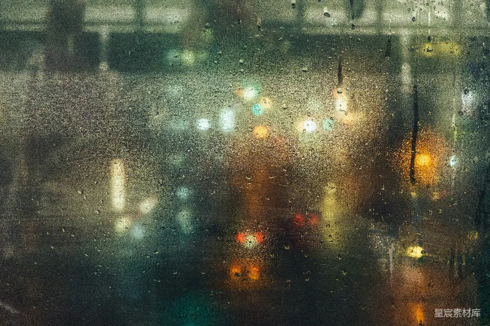 高清摄影 雨滴落在玻璃上，映着模糊的城市灯光