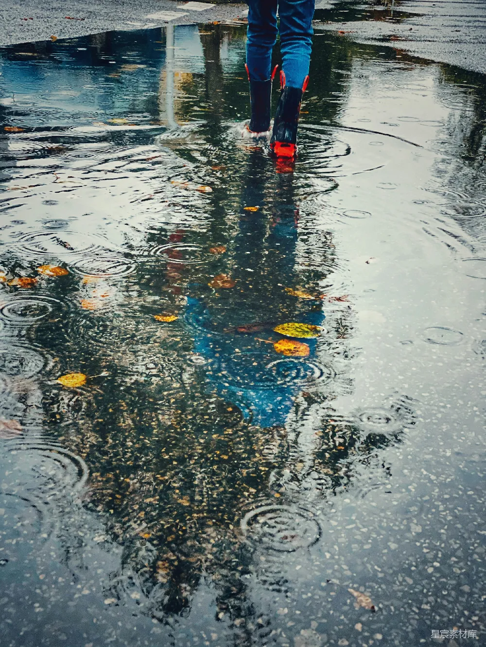 高清摄影 穿着红黑相间雨靴的人正走向水洼。