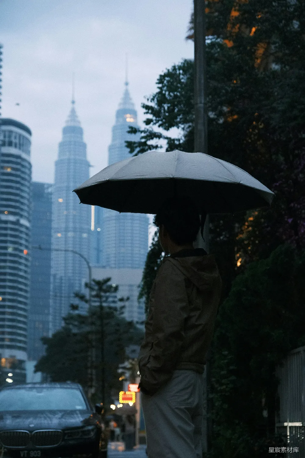 高清摄影 撑伞的男人望着雨中城市的天际线。