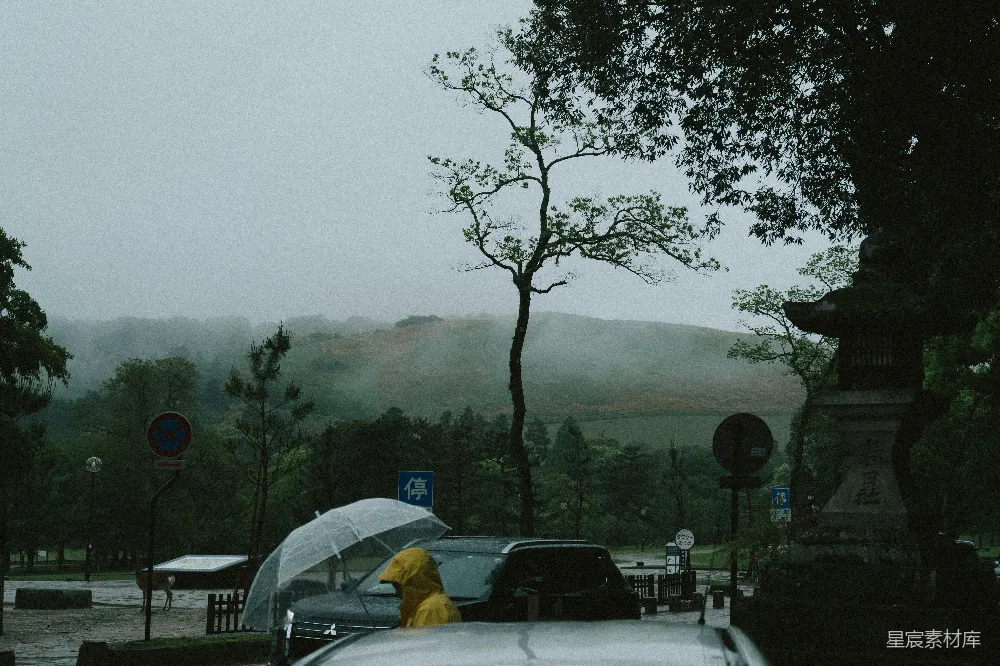 高清摄影 一个穿着黄色雨衣的人拿着一把伞