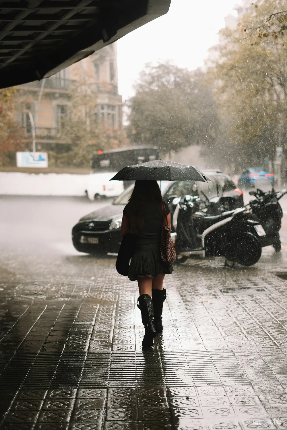 高清摄影 一个女人打着伞在雨中行走。