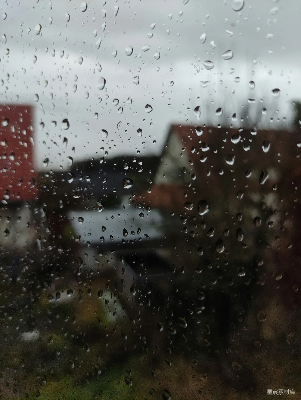 高清摄影 窗前覆盖着雨水的房子在背景中