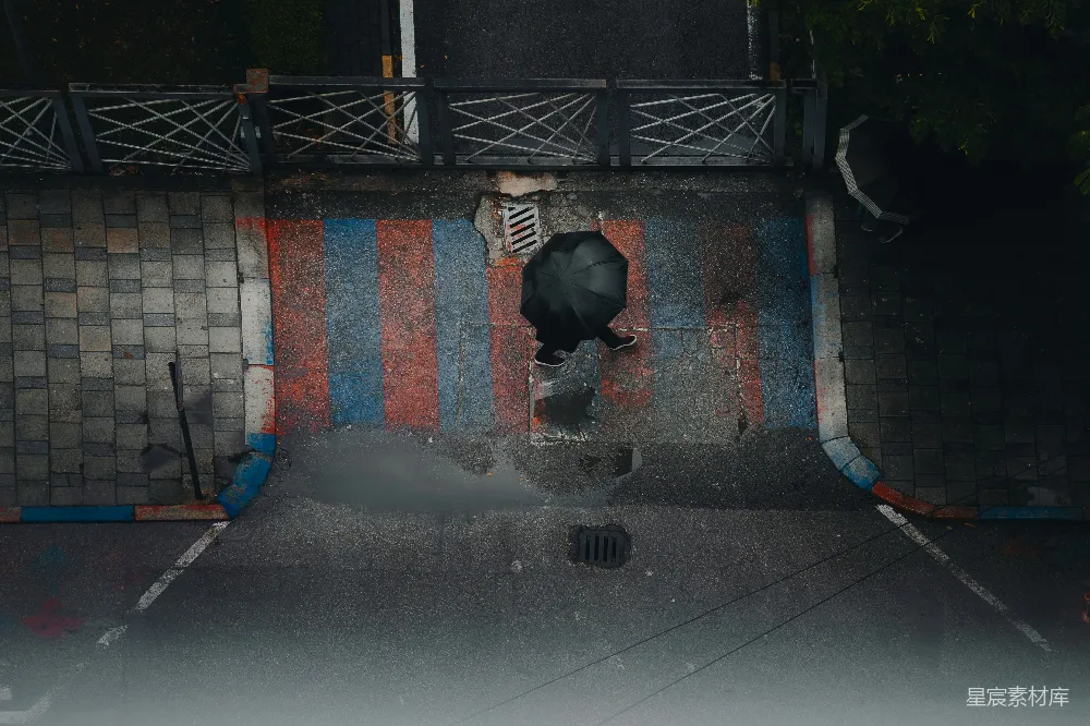 高清摄影 一个人打着伞在雨中行走。