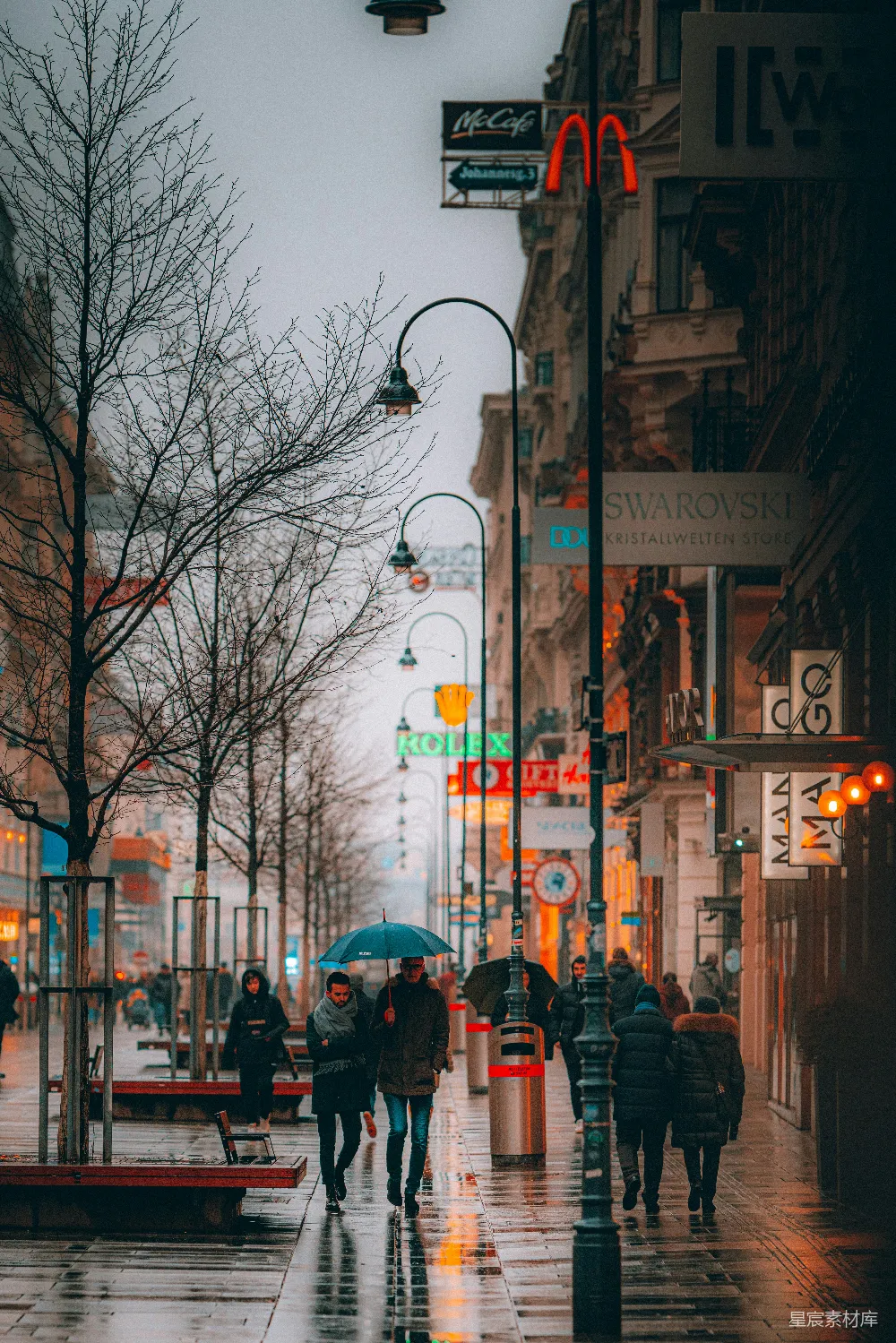 高清摄影 白天人们在 sidewalk 上行走，手中拿着伞。