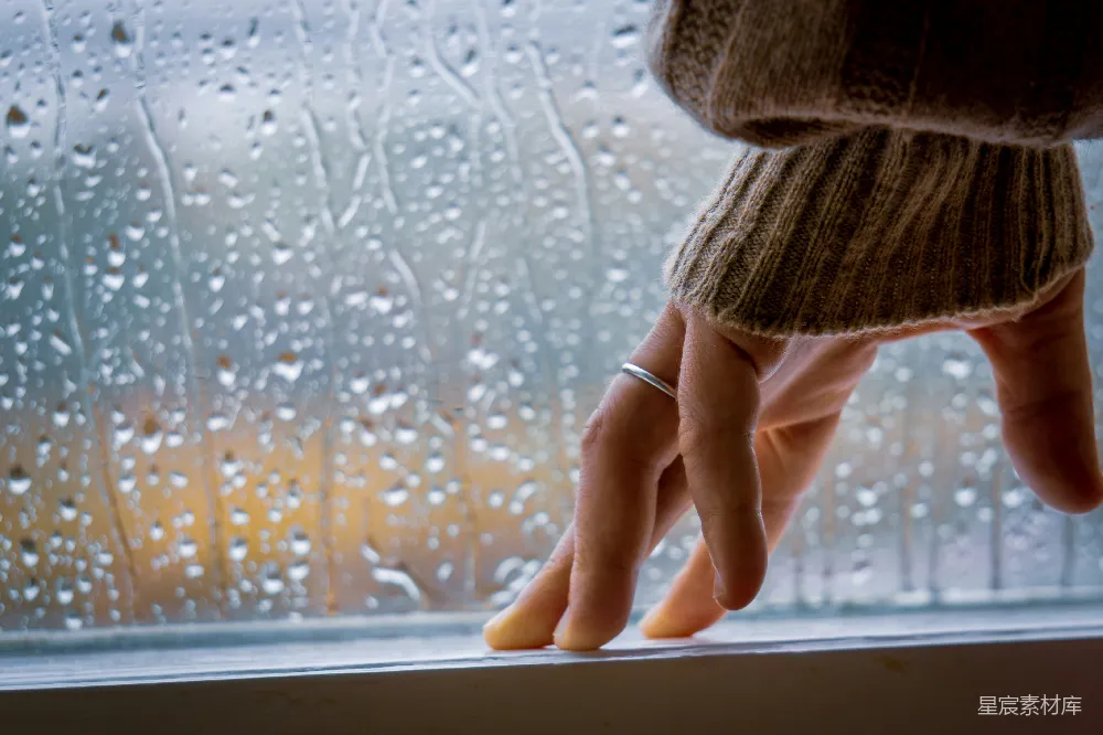 高清摄影 一个穿着衣服的人的手放在窗台上，上面有雨滴。