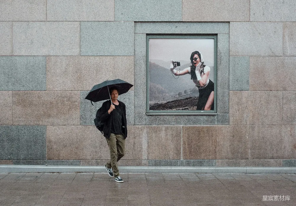 高清摄影 一个男人走在人行道上拿着雨伞