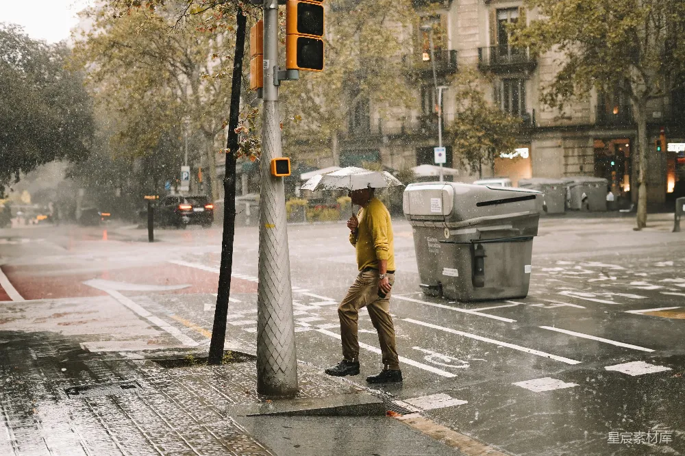 高清摄影 一个男子走在街上拿着雨伞。