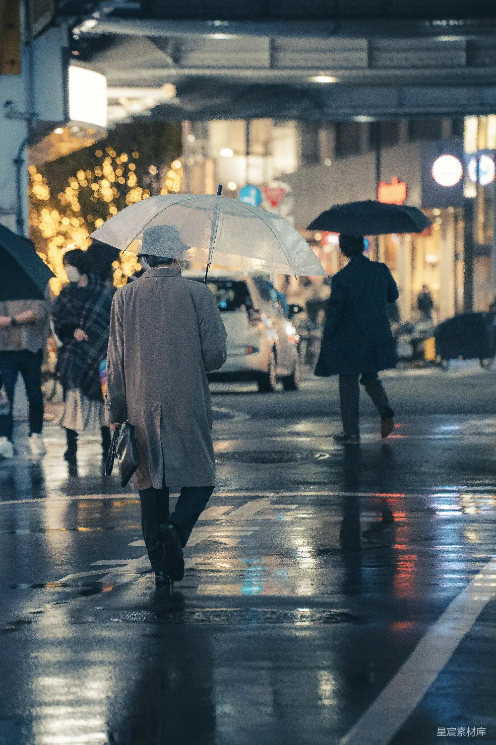 高清摄影 一群人在街上行走，手中拿着雨伞。