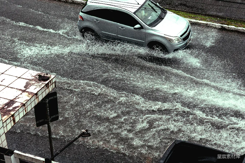 高清摄影 汽车在暴雨中行驶于积水街道上。