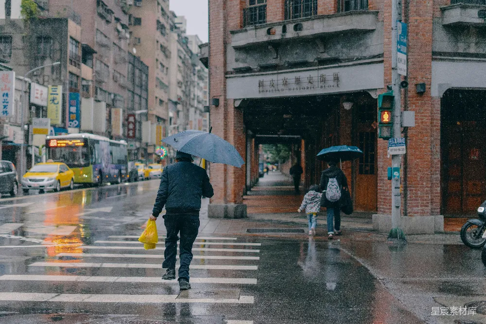 高清摄影 黑色夹克和黄色裤子的人拿着雨伞在人行道上白天行走